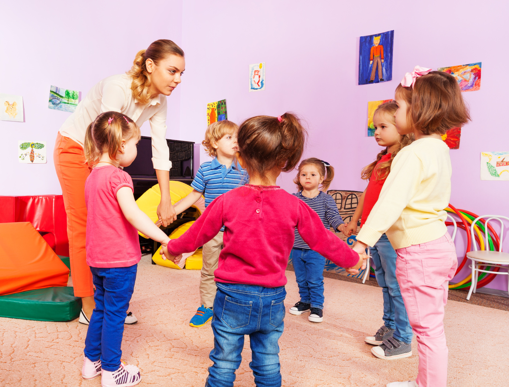 Воспитатель и группа детей в детском саду