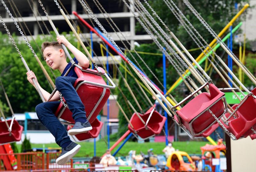 Ребенок катается на аттракционе в Центральном парке культуры и отдыха им. Горького в Москве