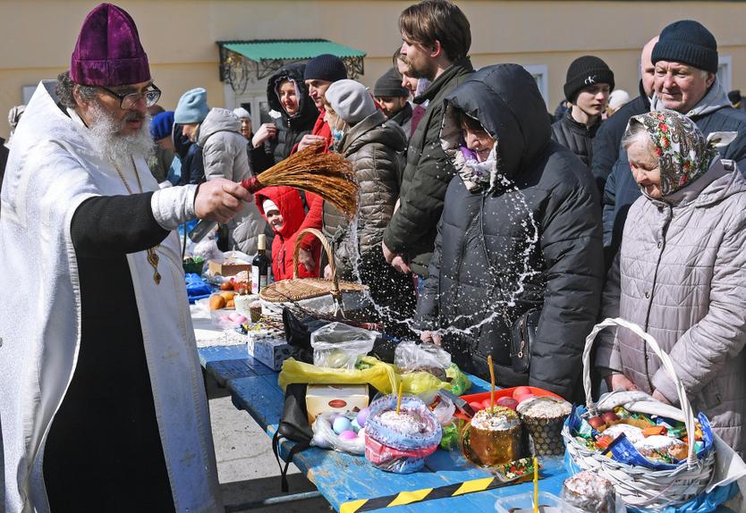 Священнослужитель освящает пасхальные куличи и яйца у Вознесенского кафедрального собора в Новосибирске