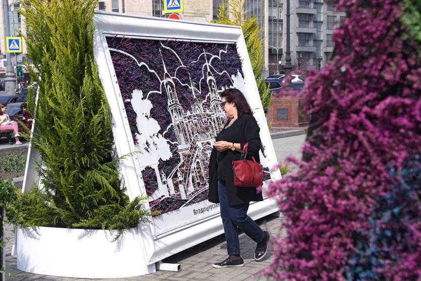 Женщина рассматривает цветочное панно во время фестиваля "Пасхальный дар" в Москве.