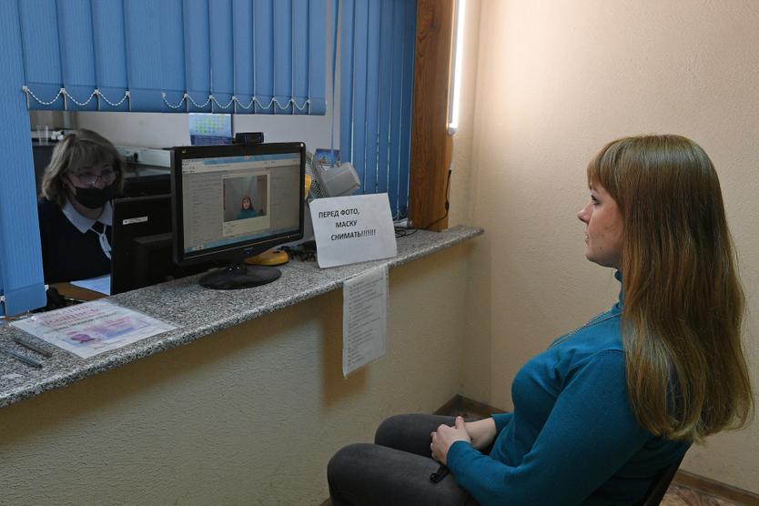 Девушка фотографируется для получения водительского удостоверения в ГИБДД