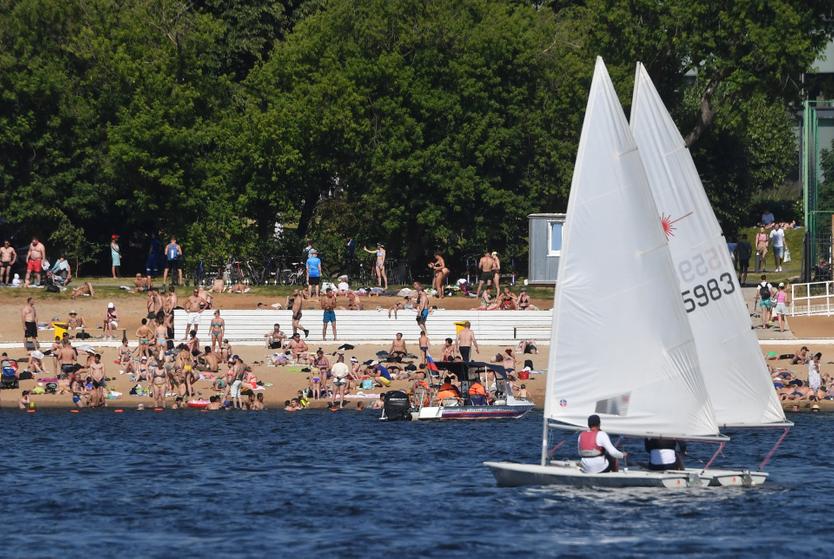 Парусная яхта и отдыхающие на пляже "Динамо" на Химкинском водохранилище.