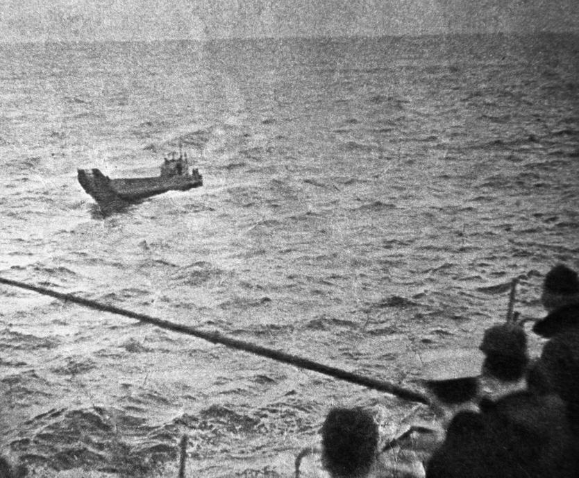 Американские моряки авианосца «Кирсардж» смотрят на баржу, на которой с 17 января по 7 марта 1960 года дрейфовали советские военнослужащие