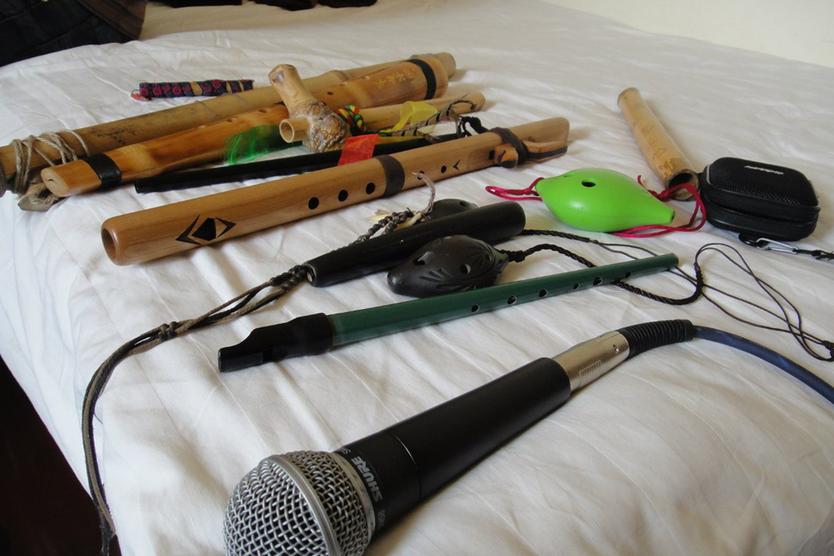 Флейты, вистлы, варганы и микрофон выложены на кровать во время сборов на выступление в Китае