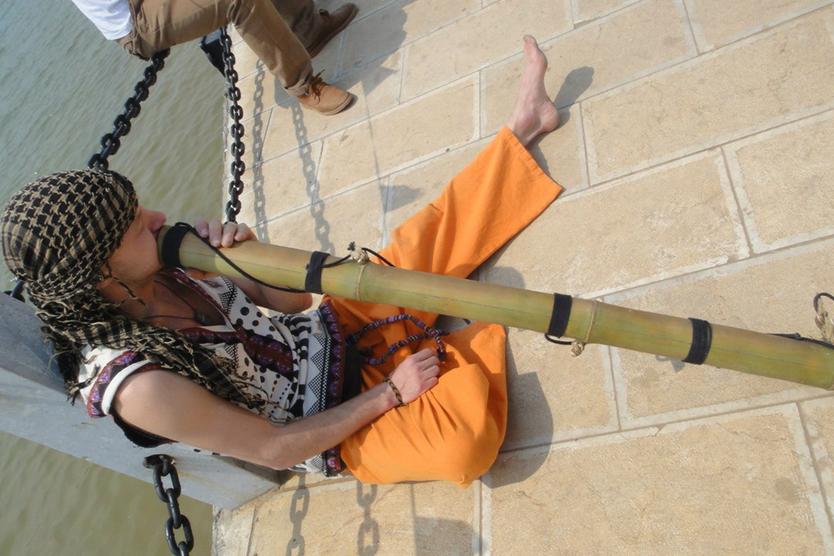 Петр Нестеров играет на диджериду на берегу лотосового озера. Лотосы в кадр не вошли